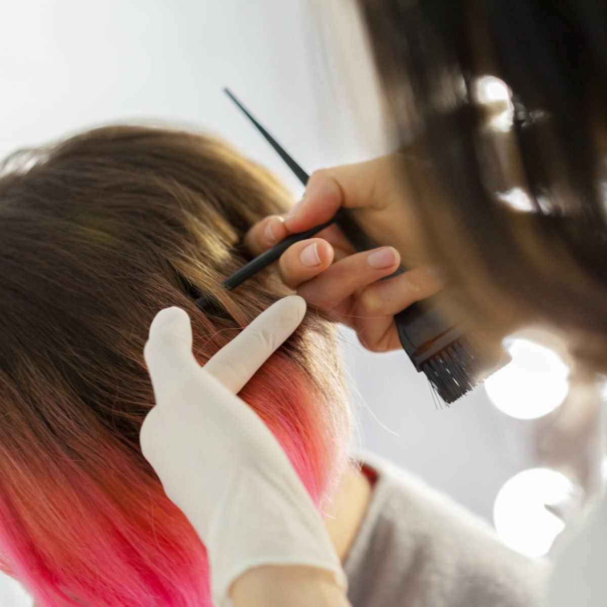 Hairdresser does hair style of woman