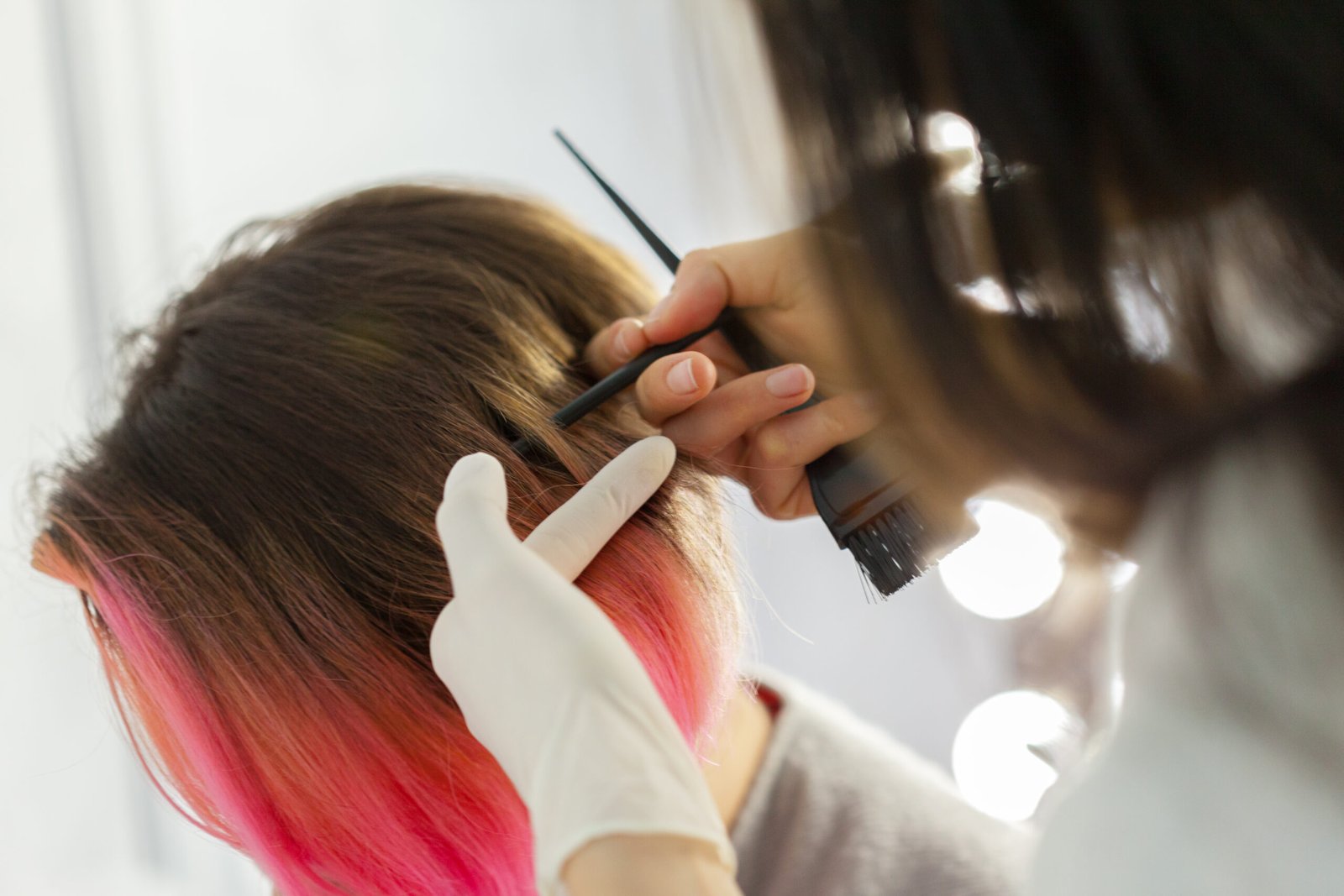 Hairdresser does hair style of woman